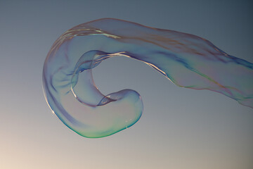 Giant colorful bubble. Big soap bubble on blue sky. Making huge rope soap bubbles.