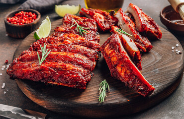 Mexican barbecued ribs seasoned with a spicy tomato sauce served on a wooden chopping board on a...