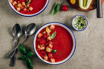 Spanish summer cold soup gazpacho with vegetables on concrete background.