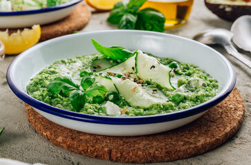 Cold green soup Gazpacho with cucumber, green peas, basil leaves and avocado.