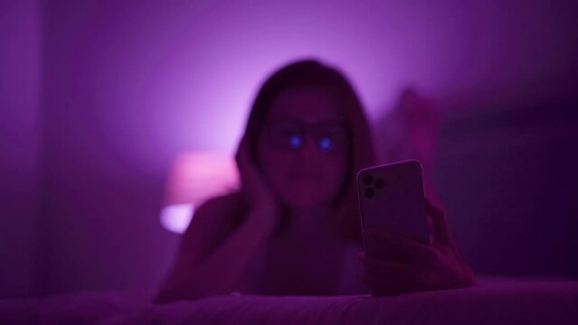 Girl lays on bed late at night taking selfies with flash on