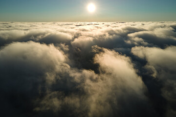 Fototapeta na wymiar Aerial view at high altitude of dense puffy cumulus clouds forming before rainstorm in evening