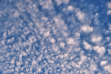 Bright landscape of white puffy clouds spread on blue clear sky