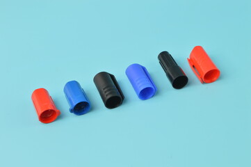 Marker pen caps in a row isolated on a blue background
