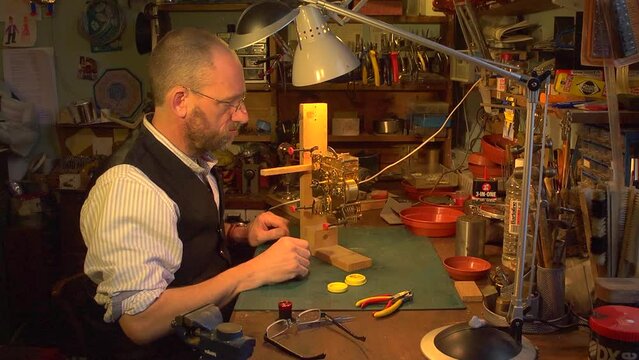 Clockmaker restoring clock mechanism on a jig