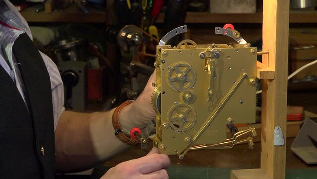 Clockmaker testing a clock mechanism, closeup