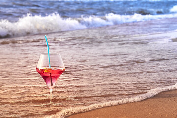 Wine glass with a cocktail by the sea.