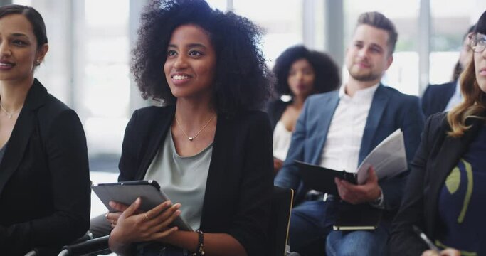 Shes an extensive note-taker. 4k video footage of an attractive young businesswoman asking questions and taking notes during a conference.