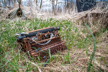 A rusted antique typewriter rests on the ground in a forest beside a section of the Bruce Trail that runs through Hamilton, Ontario.