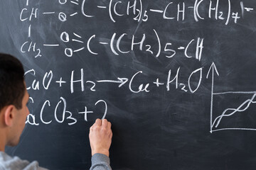 Chemistry lesson, chemist student or teacher writes formulas with chalk on blackboard, chalkboard and man handwritten, chemistry science education