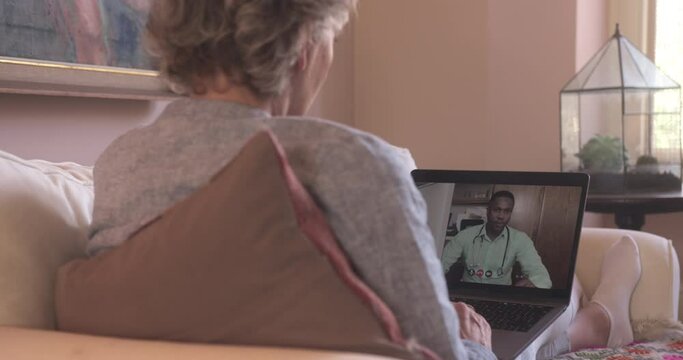 Senior Adult Woman Speaking to Doctor on Video call at Home on Sofa