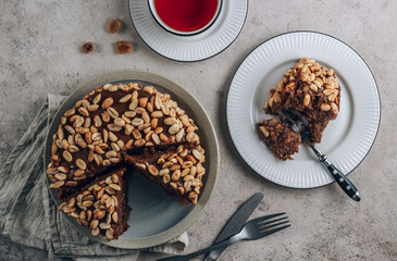 Chocolate cake with caramel cream and peanut on concrete background