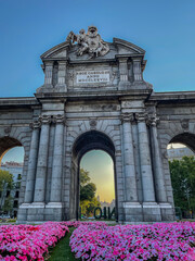 Fototapeta na wymiar Beautiful view of the iconic (Puerta de alcala) alcala gate in spring, cover in flowers on a sunset 