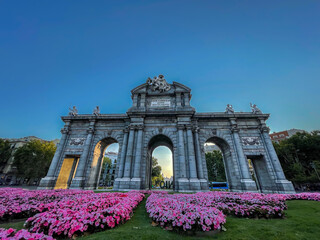 Obraz premium Beautiful view of the iconic (Puerta de alcala) alcala gate in spring, cover in flowers on a sunset 