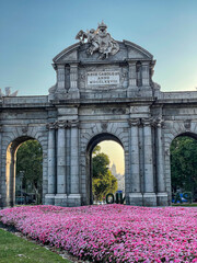 Obraz premium Beautiful view of the iconic (Puerta de alcala) alcala gate in spring, cover in flowers on a sunset 