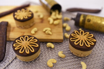 Crunchy cashew nuts  and homemade chocolate Bajadera cookies on wooden board.