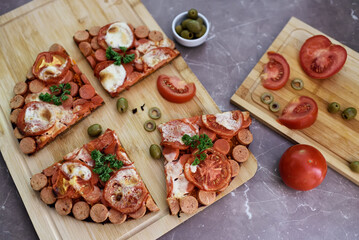 Pizza with sausages, tomato, cheese, olives.
