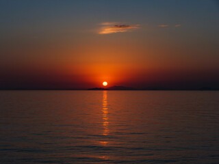 Fototapeta na wymiar 瀬戸内海の島陰に沈む夕日、横構図 