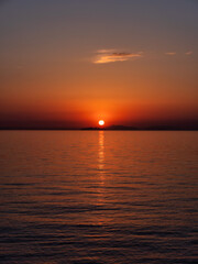 瀬戸内海の島陰に沈む夕日、縦構図
