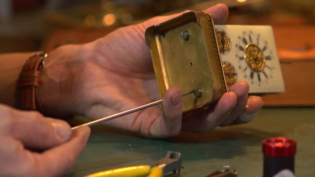 Clockmaker working on a carriage clock - close up case opening
