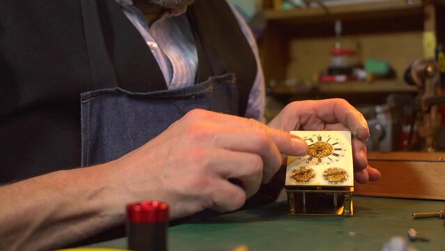 Clockmaker setting hands on a carriage clock - close up