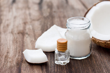 Coconut oil and fresh coconut fruit on rustic wooden table background. 