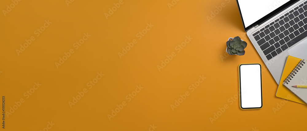 Poster flat lay smart phone, laptop computer and notepad on yellow background with copy space for your info