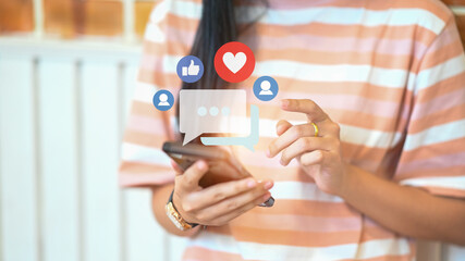 Young woman watching video live streaming on smart phone, sharing and commenting in online community.