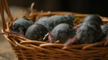 Easter card with a copy of the place for the text. Purple, blue eggs in a basket on a dark newspaper background. Natural dye karkade tea.