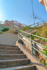 Staircase with concrete steps and painted green metal bar handrails in San Francisco, California