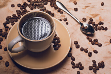 Un deliciosos café sobre una mesa de madera y granos de café esparcidos 