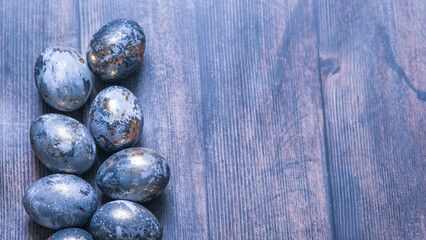 Easter card with a copy of the place for the text. Very Peri 2022 .Purple, blue eggs in a basket on a dark newspaper background. Natural dye karkade tea.