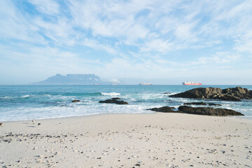 landscape view of Table Mountain and container ships anchored in Table bay from Bloubergstrand beach Cape Town