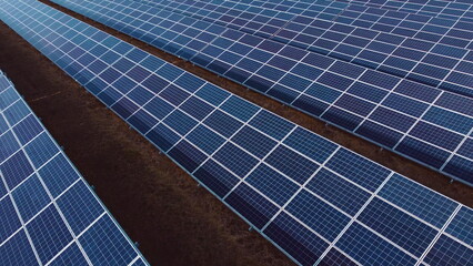 Aerial drone view flight over solar panels on sunny day close-up. Photovoltaic solar panel. Moving...