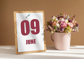 june 9. 9th day of month, calendar date.Bouquet of dead wood in pink mug on desktop.Cork board with calendar sheet on white-beige background. Concept of day of year, time planner, summer month