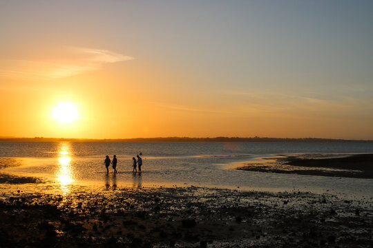 Low tide at Victoria Point. Families walking home and children playing as the sun sets