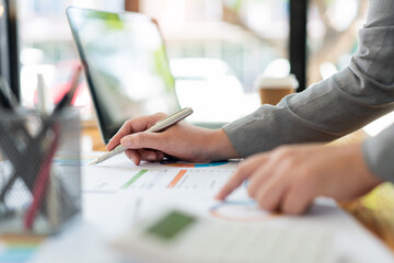 Business analyst concept the data analyst calculating the diagrams about the sale on the paperwork