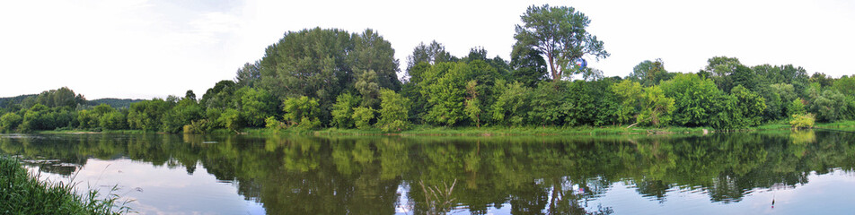 Fototapeta na wymiar Neris River in Vilnius. Picturesque River Bank. River Reflection. Summer Landscape In Lithuania