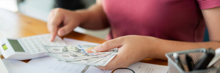 Saving concept the female saver pressing a calculator to estimate the amount of cash