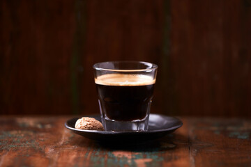 Coffee in glass cup on rustic wooden background. Copy space.