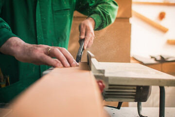 Unrecognizable Man working And Cutting The Wood On A Machine Tool Called A Table Saw In A Carpentry...