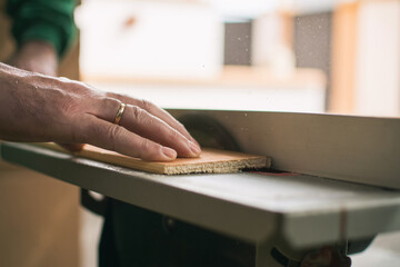 Hands Of A Man Making Custom Furniture Wood Parts On Machine Tool Called Table Saw In Woodworking Shop. Wood Production Concept. Detail