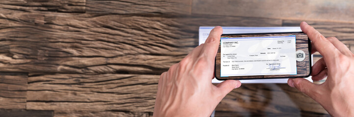 Man Taking Photo Of Cheque To Make Remote Deposit