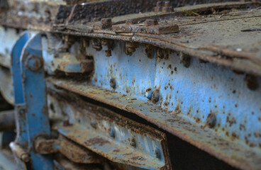 Fototapeta na wymiar Rusting metal. At the junkyard. Perished agricultural history. Abandoned and rusted machinery.