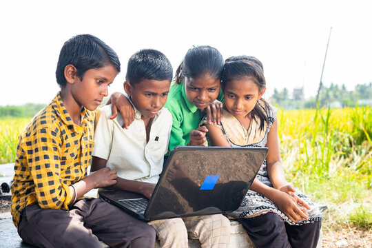 Group Of Village Kids Busy Using Laptop Near Paddy Field - Conept Of Online Education, Technology And Learning.