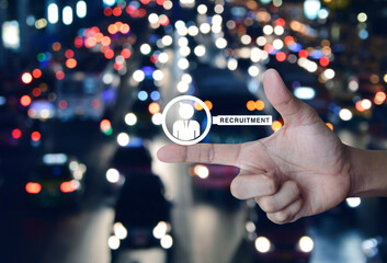 Businessman with magnifying glass icon on finger over blur colourful night light rush hour road in city, Business recruitment concept