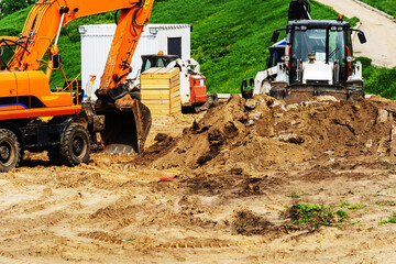 Excavator and bulldozer level the soil at the construction site. Preparation for the construction...