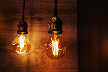 LED lamps of classical shape in retro style on the background of a wooden wall. Selective focus. Close-up