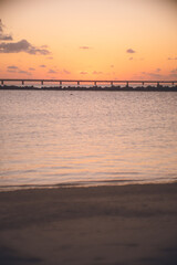 Fototapeta na wymiar 沖縄県の離島 宮古島の伊良部大橋に沈む赤い夕陽をトゥリバー海浜公園サンセットビーチから眺める