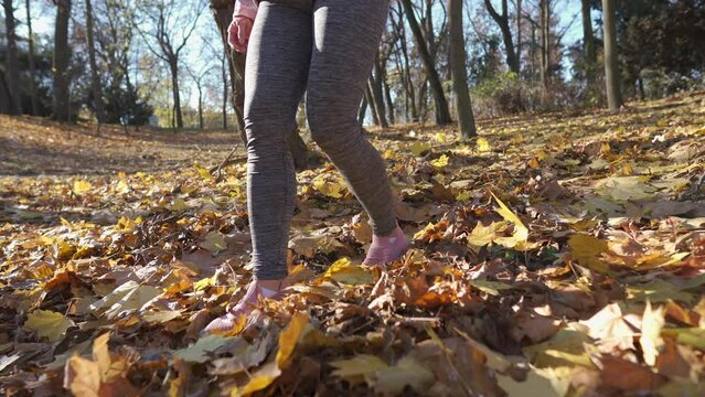 Sleek women's legs during an autumn walk in a city park.